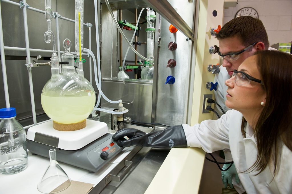 Two chemists, man and woman, work together in the lab