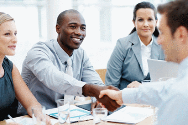 Handshake at the start of an interview, two hiring managers and one applicant