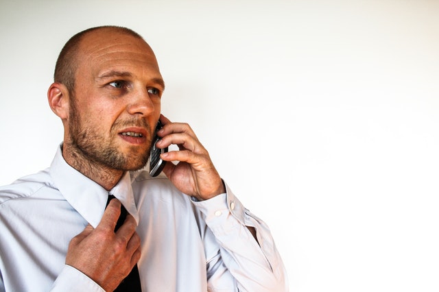 man is nervous on the phone, sharing a sensitive information with his colleague