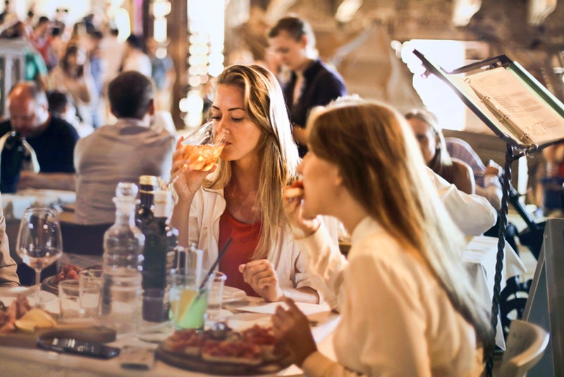 Two women enjoy a lunch over a job interview in an italian restaurant