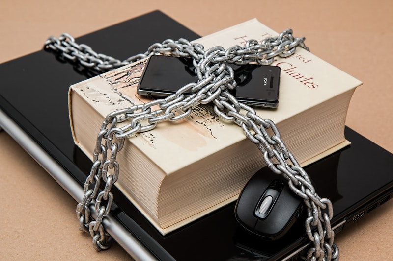 computer, book and phone in chains, illustration of some security