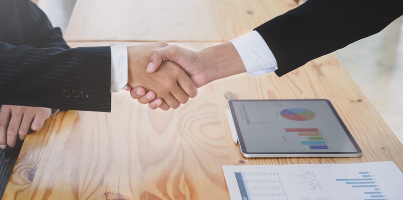 two contract parties shake hands after reaching agreement
