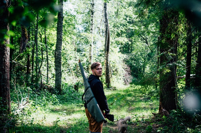 park ranger walks in the forest with their dog
